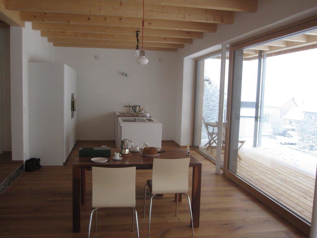 Holzboden und Tisch mit Blick auf Terrasse und winterlichen Garten